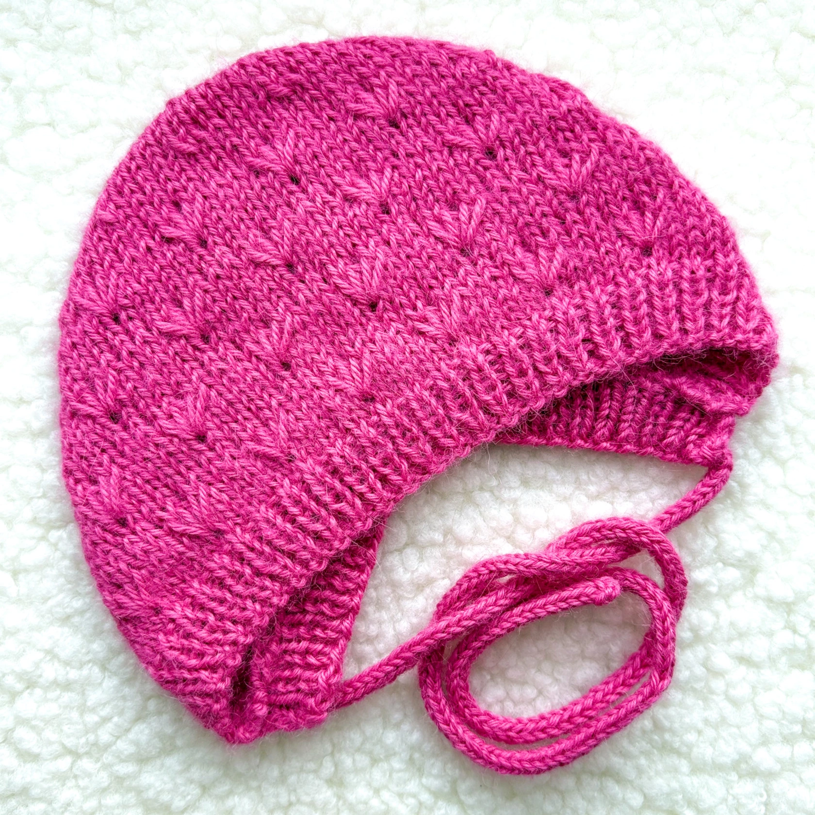 Handgestrickte Babyhaube in strahlendem Pink Handgestrickte Babyhaube in strahlendem Pink